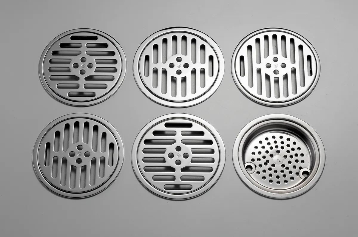Vários modelos de grelhas de ralo dispostos em uma superfície