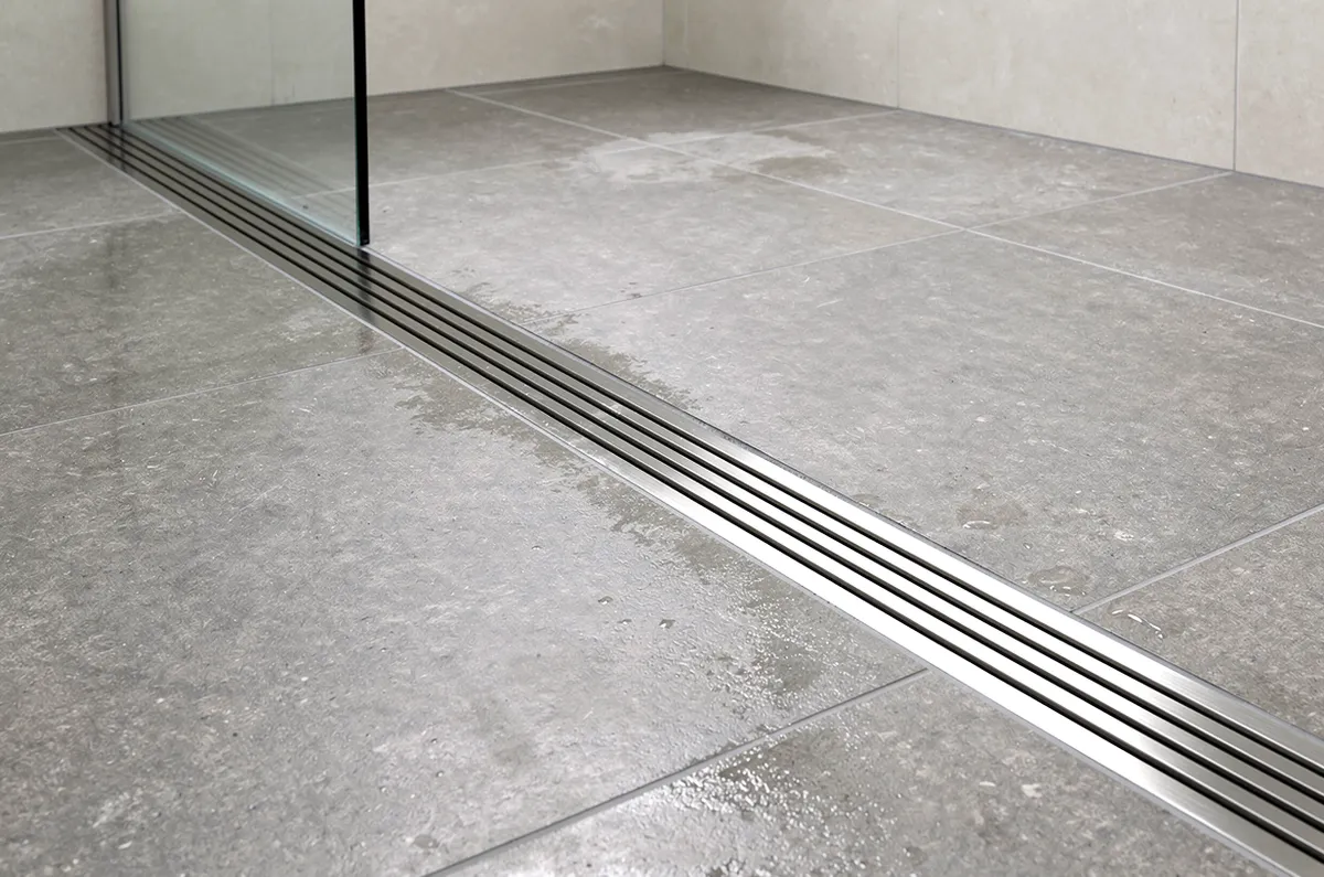 Ralo linear de inox comprido em um banheiro moderno