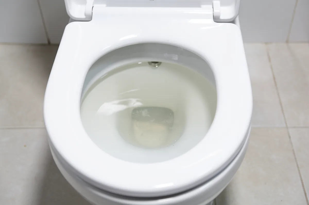 Vaso sanitário com água turva subindo, sinal de entupimento